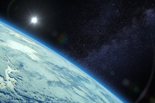 Planet Earth, Sun and Milky Way galaxy, view from orbit. View from a spacecraft with sunlight glinting on the ocean. 