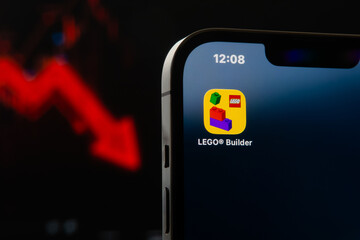 Fototapeta premium LEGO Builder app icon on screen with a red graphic falling to the background, representing a decline in toy sales or brand value. Sonora, Mexico - January 28, 2026