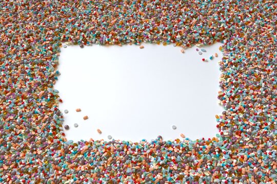 Variety of pills surrounding empy white area, illustration