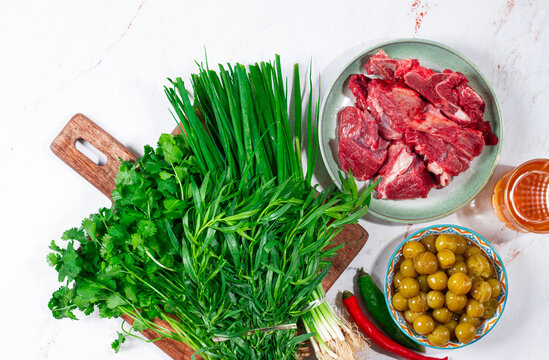 ingredients for cooking chakapuli, canned tkemali, meat, herbs Georgian cuisine, top view,