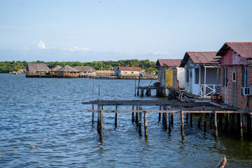 A small village with houses on stilts and a pier © Henrry L