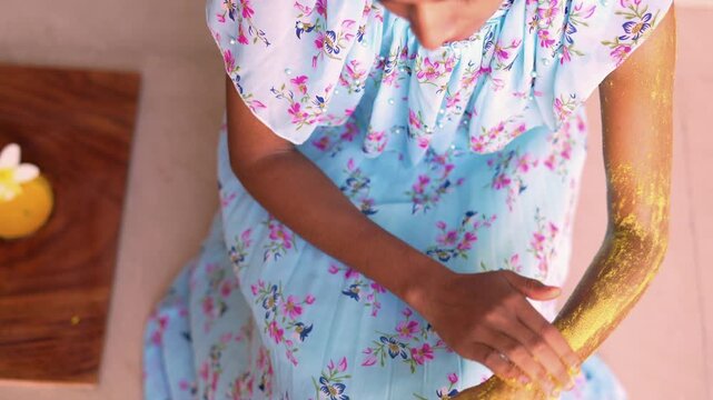 A woman applying homemade ubtan skincare mask on her arm and hands. Close up of Lady using natural cosmetic on body. Ayurvedic beauty treatment for clean skin. Ubtan paste massage at home.