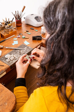 Unrecognisable Woman Checking Variscite Stone in a Workshop With Tools and Materials Scattered.