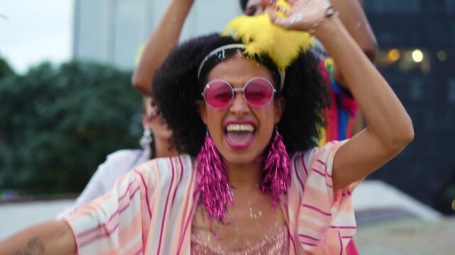 Joyful African American woman dancing with enthusiasm during colorful Brazilian Carnival parade. Festive crowd celebrating in vibrant costumes at a lively street party