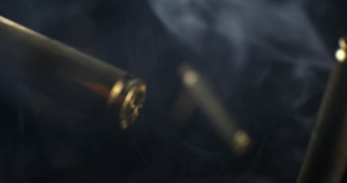 Slow Motion Macro Shot Of Brass Bullet Casings Burst On Black Background. Concept Of Ammunition, Industry And Impact