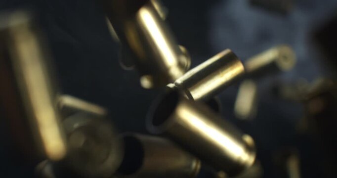 Slow Motion Macro Shot Of Brass Bullet Casings Burst On Black Background. Concept Of Ammunition, Industry And Impact