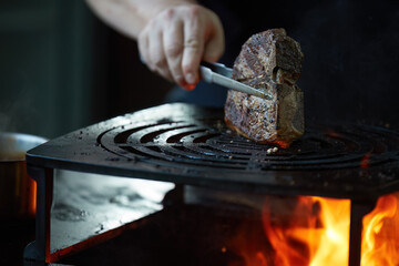 Grilling meat on open fire pit with dynamic flames for outdoor gourmet barbecue and catering services