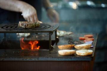 Beef steak grilling over open fire on barbecue grill with flames and smoke. Ideal for: food advertising, barbecue marketing, restaurant promotion, outdoor cooking, premium meat concepts.