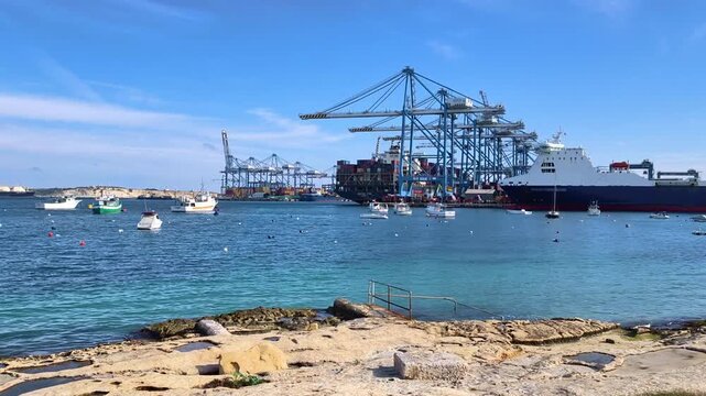 Panoramic view of Birzebbuga harbor with industrial port, cargo ships, boats under blue sky