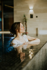 Woman enjoys relaxing moment in a pool at a wellness center during the day