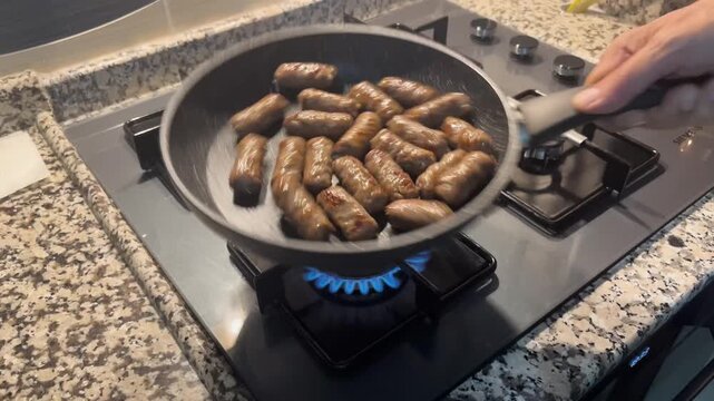 Delicious Tekirdağ meatballs sizzling appetizingly in a pan on the stove. A concept of preparing hot and fresh meals in the kitchen based on traditional Turkish cuisine.