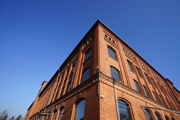 Fensterfront einer alten Fabrik mit Fassade aus Backstein vor blauem Himmel im Sonnenschein in der Klassikstadt im Stadtteil Fechenheim in Frankfurt am Main in Hessen	
