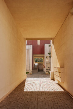 Sunlit architectural passage with paved pathway