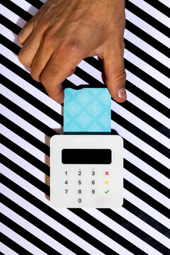 Hand inserting credit card into white card reader