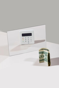 Credit card reader and dollar bill on white background