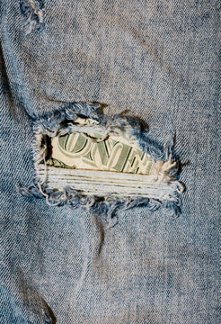 Torn jeans revealing dollar bill