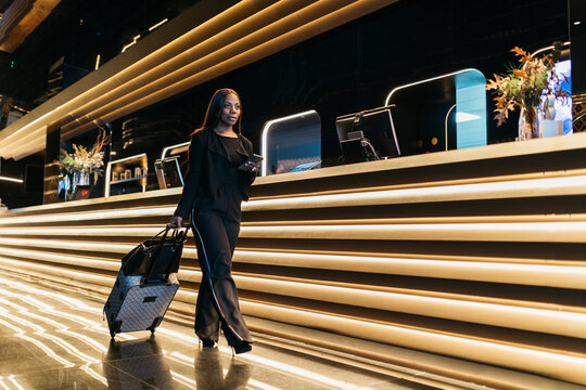 Guest arriving at hotel reception with suitcase