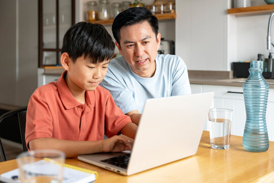 Father and son bonding over technology at home