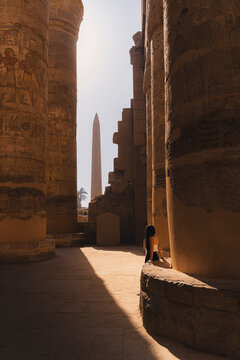 Ancient Egyptian columns and obelisk in sunlit desert