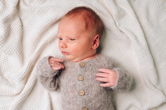 Peaceful newborn in a cozy knitted outfit