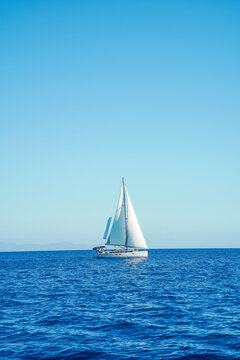 Sailboat under clear blue sky on calm sea