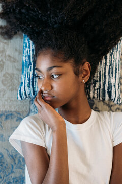 Young girl lying on patterned rug with thoughtful expression