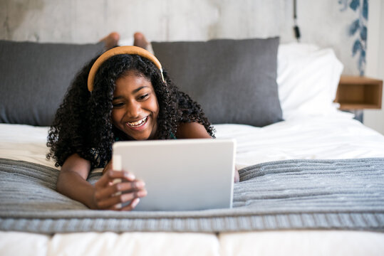 Girl enjoying tablet time in bed
