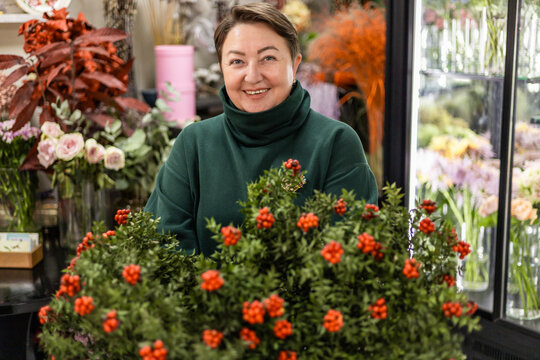 Florist with Ruscus berries in flower shop setting