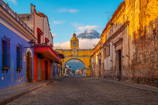 Antigua main street at sunrise with Agua volcano and Santa Catalina arch, Guatemala.