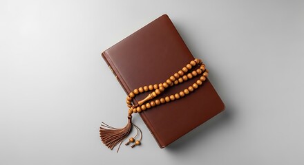 Beautiful brown leather journal with prayer beads on a simple gray background