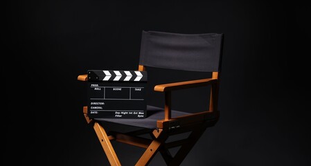 Film director's chair with clapperboard on black background, closeup © New Africa