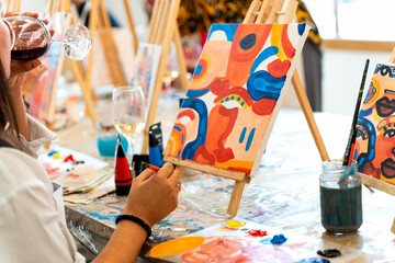 Friends enjoying art and wine painting workshop