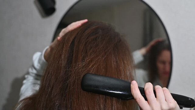 Hair styling with curling iron, curling and straightening beauty routine concept
