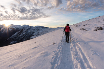 Hiker walking at sunset on snowy terrain. Hautes-Pyr&eacute;n&eacute;es. French Pyrenees