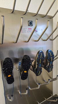 Steeg, Tirol, Austria - July 26, 2025. A metal shoe dryer made of high-quality stainless steel in a hotel Bergmahd at a ski resort, with two pairs of hiking boots hanging on it.
