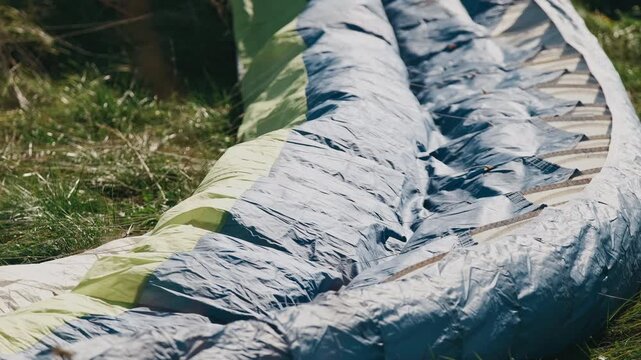 Paraglider Wing Laid On Grass, Sunlit Meadow Closeup Showing Ripstop Fabric, Lines And Cord Detail During Preflight Setup