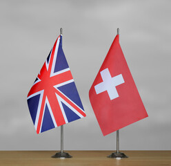 Table flags United Kingdom and Switzerland on grey blurred background