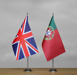 Table flags United Kingdom and Portugal on grey blurred background