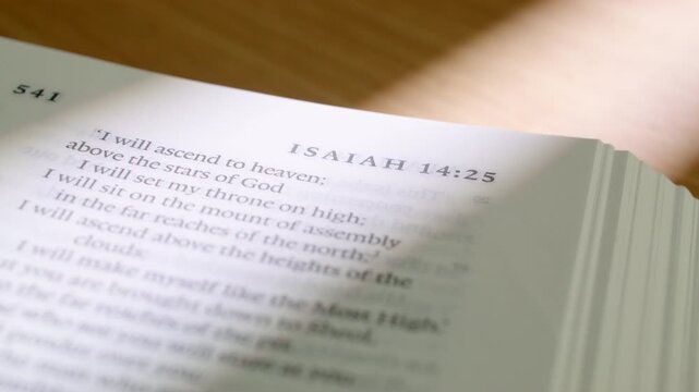 Bible Isaiah 12 white pages turning book holy scripture close up. Extreme detailed shot of flipping paper in the Old Testament prophecy book about salvation and praise in a modern study setup.