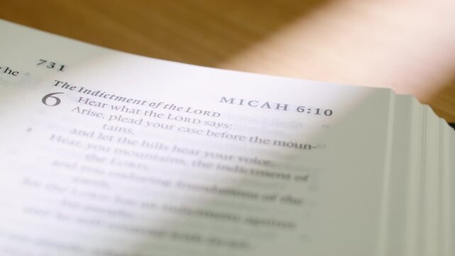 Bible Micah book pages turn during a close up study of holy scripture. Detailed shot of flipping through white paper in the Old Testament prophet book in a modern religious book for study.
