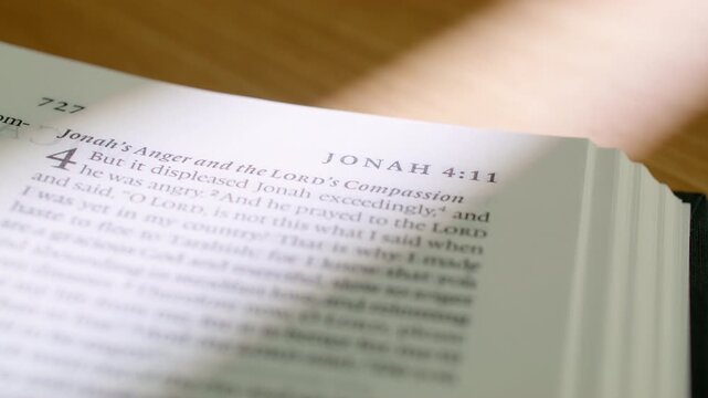 Bible Obadiah and Jonah pages turn during a close up study of holy scripture. Witness the transition from the prophecy of Obadiah to the narrative of Jonah in a modern religious book for study.