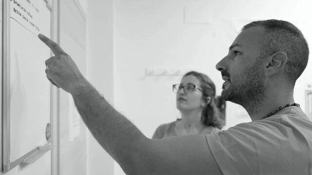 Team of employees reviewing schedules and work assignments on the task board