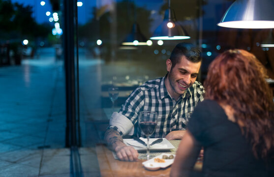 Young couple in modern restaurant having dinner with night ambient light