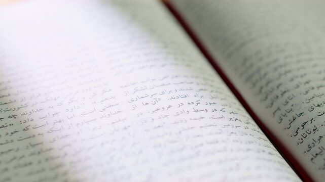 Bible pages flipping in Farsi language. Close up shot of the Holy Bible in Persian script during a study session. 4K video of religious scripture, Middle Eastern faith, and prayer reading.