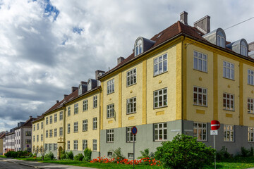 Yellow Residential Apartment Block in Torshov Oslo Norway showcasing Nordic Classicism Architecture with Arched Dormer Windows and Historic Masonry Facades