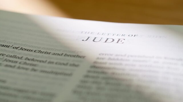 Bible pages flipping to Jude letter book. Turning pages of the New Testament letter regarding contending for the faith and God's protection. 4K close up shot for religious study and scripture.