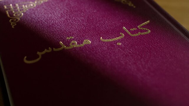 Persian Bible pages flipping open to Farsi text. Close up shot of the Holy Bible in Farsi language. 4K footage of religious scripture reading, spiritual study, and Middle Eastern Christianity.