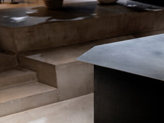Abstract detail of steel countertop edge meeting concrete steps in minimalist kitchen