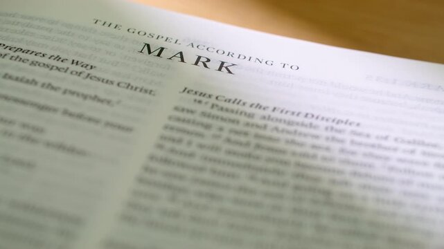 Bible Mark book pages turn during a close up study of holy scripture. A detailed shot of flipping white paper in the New Testament Gospel book focusing on the servant ministry of Jesus.
