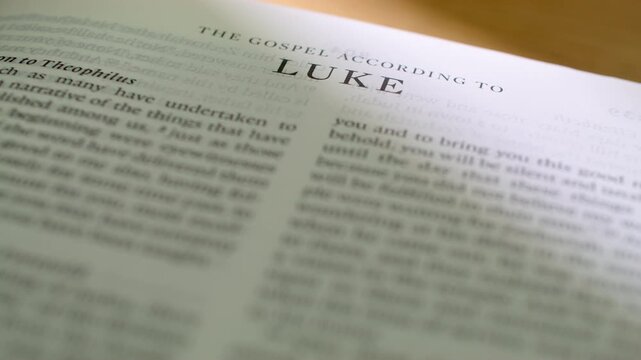 Bible Luke book pages turn during a close up study of holy scripture. A detailed shot of flipping white paper in the New Testament Gospel book detailing the life and parables of Jesus.